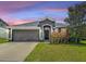 Charming single-Gathering home featuring a well-manicured lawn, attached two-car garage, and lovely landscaping at 14371 Edinburgh Moor Dr, Wimauma, FL 33598