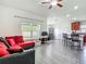 Open living room with hard floors, modern furniture, and a view of the kitchen at 14371 Edinburgh Moor Dr, Wimauma, FL 33598