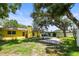 Large backyard with mature trees, a paver patio, and green grass at 1510 Patricia Ave, Dunedin, FL 34698