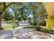 Scenic backyard with mature trees, pavers, and lush greenery, creating a private outdoor space at 1510 Patricia Ave, Dunedin, FL 34698