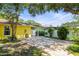 Large paver patio in the backyard of a yellow home, enclosed by a white privacy fence at 1510 Patricia Ave, Dunedin, FL 34698