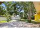 Paver patio in a spacious backyard with mature trees and a white privacy fence at 1510 Patricia Ave, Dunedin, FL 34698