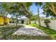 Scenic backyard featuring mature trees, pavers, lush lawn, and privacy fencing at 1510 Patricia Ave, Dunedin, FL 34698