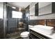 Modern bathroom featuring black tiled walls, glass shower with pebble floor, and floating shelves at 1510 Patricia Ave, Dunedin, FL 34698