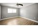 Neutral bedroom features wood floors, crown molding, ceiling fan, and a large window at 1510 Patricia Ave, Dunedin, FL 34698