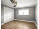 Empty bedroom with neutral walls, wood flooring, a large window, and a double closet at 1510 Patricia Ave, Dunedin, FL 34698
