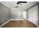 Spacious bedroom with wood-look flooring, crown molding, a ceiling fan, and a closet at 1510 Patricia Ave, Dunedin, FL 34698