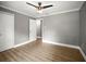 Bedroom with wood-look flooring, gray walls, a ceiling fan, and a closet at 1510 Patricia Ave, Dunedin, FL 34698