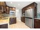 Updated kitchen with dark cabinets, stainless appliances, mosaic backsplash, and granite countertops at 1510 Patricia Ave, Dunedin, FL 34698