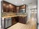 Kitchen with wood cabinets, mosaic tile backsplash, stainless steel appliances, and granite countertops at 1510 Patricia Ave, Dunedin, FL 34698