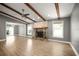 Spacious living room with wood beams, fireplace, wood floors, and a ceiling fan at 1510 Patricia Ave, Dunedin, FL 34698