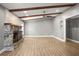 Living room featuring a stone fireplace, wood beams, laminate flooring, and a neutral paint scheme at 1510 Patricia Ave, Dunedin, FL 34698