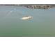 Scenic aerial view of a sandbar island with lush foliage, palm trees, and pristine surrounding waters at 1591 Gulf Blvd # 304S, Clearwater Beach, FL 33767
