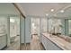 This well-lit bathroom has double sinks, stylish fixtures, and a large mirror over the marble countertop at 1591 Gulf Blvd # 304S, Clearwater Beach, FL 33767