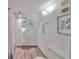 Bright bathroom featuring a shower, toilet, light fixtures and decor at 1591 Gulf Blvd # 304S, Clearwater Beach, FL 33767