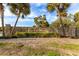 Inviting entrance to Sand Key community with a stone wall, lush greenery, and palm trees at 1591 Gulf Blvd # 304S, Clearwater Beach, FL 33767