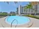 Community pool deck with lounge chairs and building in background, surrounded by lush, tropical landscaping at 1591 Gulf Blvd # 304S, Clearwater Beach, FL 33767