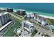 Scenic exterior view of beachfront condos with lush landscaping and a glimpse of the ocean at 1591 Gulf Blvd # 304S, Clearwater Beach, FL 33767
