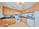 Well-lit kitchen with wooden cabinets, black granite countertops and appliances at 1591 Gulf Blvd # 304S, Clearwater Beach, FL 33767