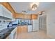 Well-lit kitchen with wooden cabinets, black granite countertops and appliances at 1591 Gulf Blvd # 304S, Clearwater Beach, FL 33767