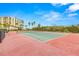 Well-maintained tennis court surrounded by tropical landscaping and palm trees at 1591 Gulf Blvd # 304S, Clearwater Beach, FL 33767