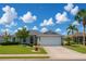 Charming single-story home featuring a well-manicured lawn, beautiful landscaping, and an attached two-car garage at 1607 Alexander Crossing Way, Sun City Center, FL 33573