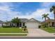 Inviting one-story home with lush green lawn, tidy landscaping, and a two-car garage at 1607 Alexander Crossing Way, Sun City Center, FL 33573
