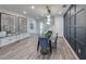 Elegant dining room with a glass table, stylish chairs, modern lighting, and decorative wall paneling at 16427 Sapphire Point Dr, Lakewood Ranch, FL 34211