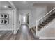 Bright hallway with wood flooring, stairs, white trim, and stylish decor leading to the front door at 16427 Sapphire Point Dr, Lakewood Ranch, FL 34211