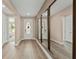 Inviting hallway with hardwood floors, large mirrors, and white doors creates a welcoming atmosphere at 16427 Sapphire Point Dr, Lakewood Ranch, FL 34211