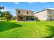 Spacious backyard features lush green lawn, screened patio, and beautiful home exterior in a serene neighborhood at 17509 Queensland St, Land O Lakes, FL 34638