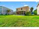 Expansive backyard featuring lush green lawn, screened patio, and beautiful home exterior in a serene setting at 17509 Queensland St, Land O Lakes, FL 34638