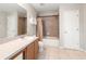 Well-lit bathroom featuring a shower-tub combo, a single sink vanity, and neutral tile flooring at 17509 Queensland St, Land O Lakes, FL 34638