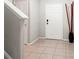 Bright foyer with neutral tile flooring, adjacent staircase, and modern decor at 17509 Queensland St, Land O Lakes, FL 34638
