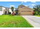 Two-story home with a manicured lawn, long driveway, and a beige two-car garage at 17509 Queensland St, Land O Lakes, FL 34638