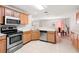 Functional kitchen with stainless steel appliances, laminate countertops, and natural wood cabinetry at 17509 Queensland St, Land O Lakes, FL 34638