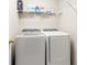 This laundry room features a modern washer and dryer with a storage shelf above for convenience at 17509 Queensland St, Land O Lakes, FL 34638