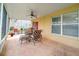 Outdoor patio with ceiling fan, tiled flooring, and comfortable seating offers a relaxing backyard view at 17509 Queensland St, Land O Lakes, FL 34638