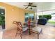 Covered outdoor patio features tile flooring, ceiling fan, and comfortable seating, perfect for relaxing outdoors at 17509 Queensland St, Land O Lakes, FL 34638