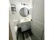 Modern bathroom featuring a round mirror, marble countertop, and a pristine white toilet at 19743 Ellendale Dr, Land O Lakes, FL 34638