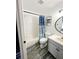 Bright bathroom features a modern round mirror, vanity, and a patterned shower curtain at 19743 Ellendale Dr, Land O Lakes, FL 34638