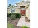 Inviting front entrance with a double door, tiled walkway, and neat landscaping at 19743 Ellendale Dr, Land O Lakes, FL 34638