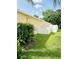 Side yard showing well-kept lawn, mature greenery, and a white fence for privacy at 19743 Ellendale Dr, Land O Lakes, FL 34638