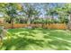 Lush backyard with manicured artificial turf, a wood fence and mature landscaping create a private outdoor space at 201 W Alva St, Tampa, FL 33603