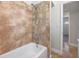 Bathroom with neutral colored tile and a tub and shower combination with an adjustable shower head at 201 W Alva St, Tampa, FL 33603