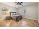 Bedroom with tiled floor, ceiling fan, side table, and natural light from the two windows at 201 W Alva St, Tampa, FL 33603