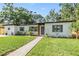 Charming single-story home featuring a lush front lawn and inviting walkway leading to the front door at 201 W Alva St, Tampa, FL 33603