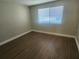 Bright bedroom with wood-look flooring, neutral walls, and a window for natural light at 209 Corkwood Ln Ln, Oldsmar, FL 34677
