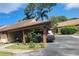 Carport with lovely landscaping and a car parked underneath in front of the property at 209 Corkwood Ln, Oldsmar, FL 34677