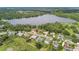 Aerial view of a neighborhood with lake access, showcasing homes with swimming pools and lush greenery at 2103 N Golfview Dr, Plant City, FL 33566